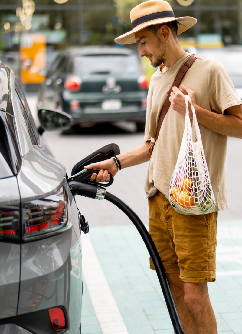 three women pick up trash on a beach