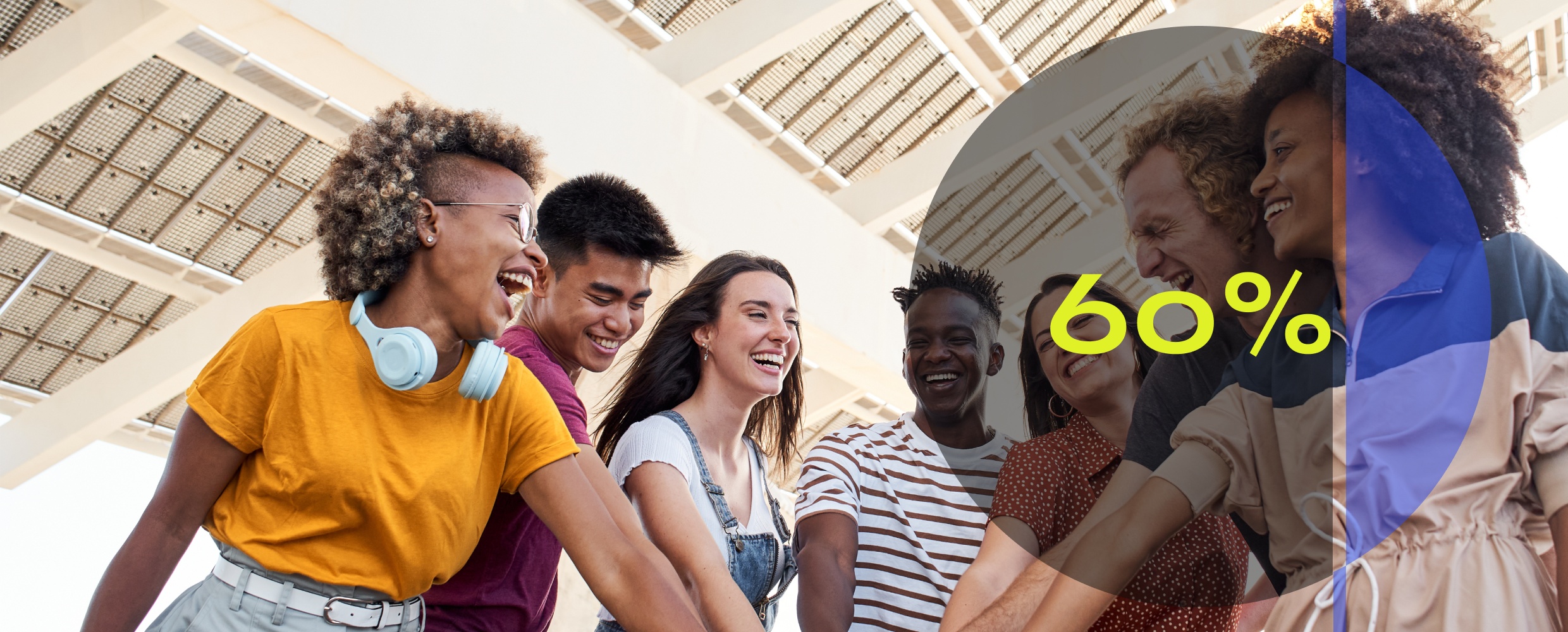 five young adults putting their hands together in a huddle