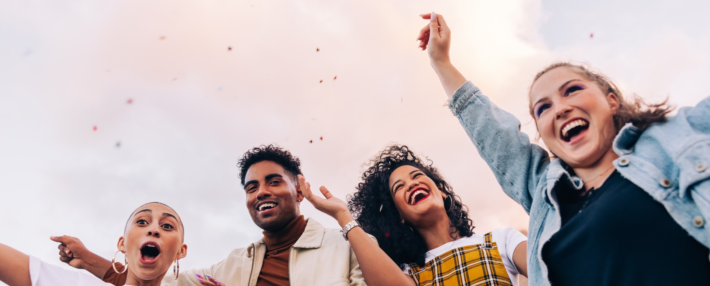 three young adults cheeering and smiling