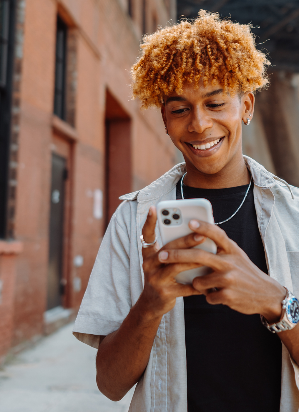 a young man walks through an alley using his phone