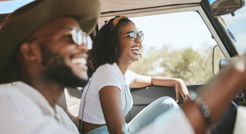 two people smiling while driving a car