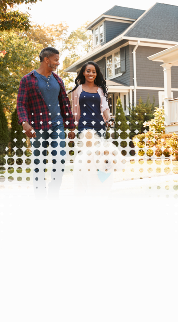 a couple walking their dog outside in a neighborhood