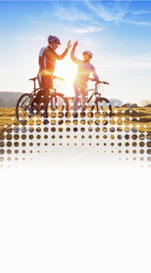 two bicyclists outside on a hill, high fiving each other