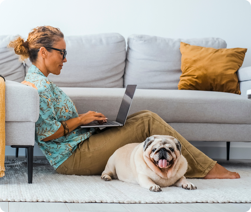 woman sitting on the floor by a couch with her dog